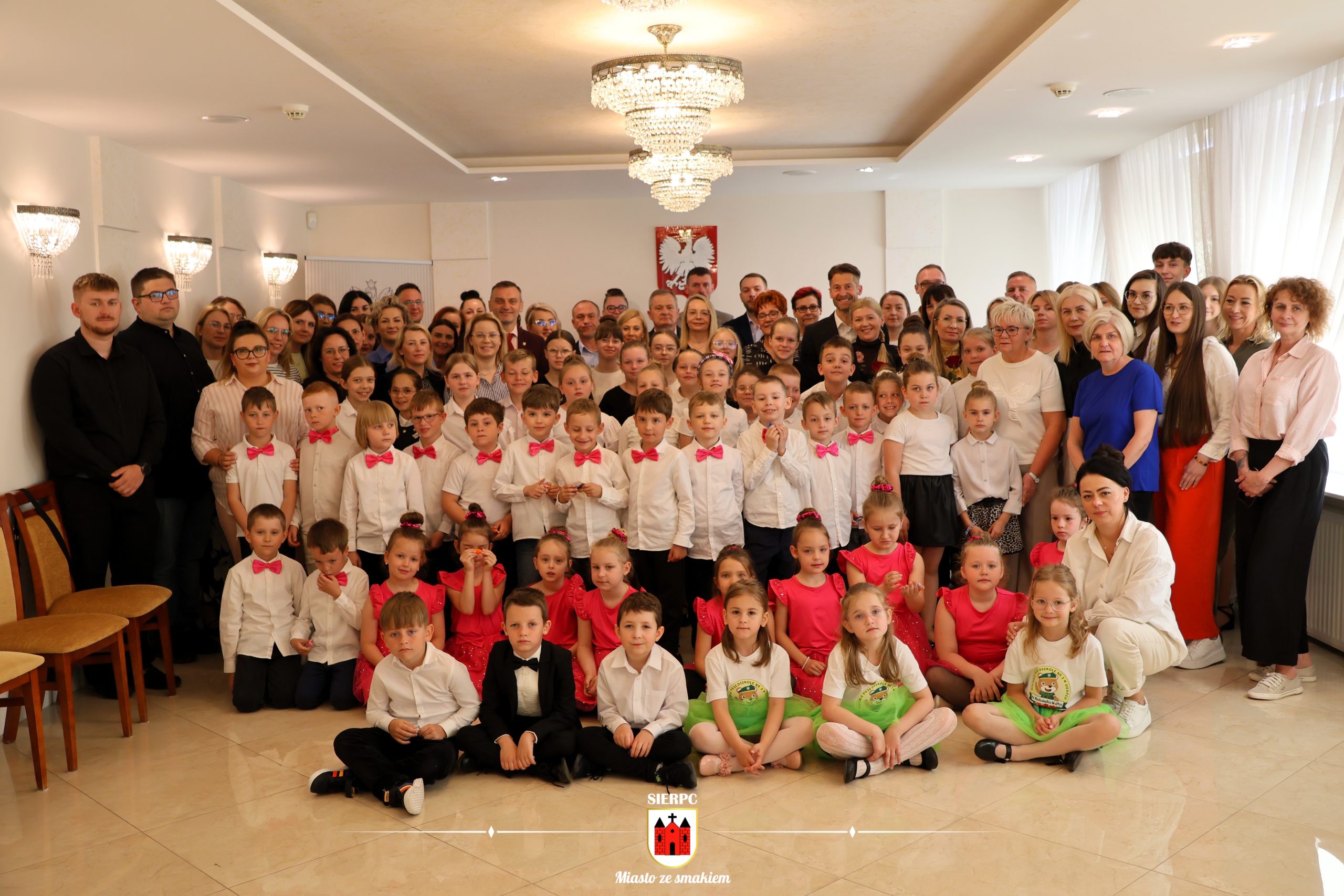 Grupowe zdjęcie pracowników Urzędu Miejskiego w Sierpcu wraz z dziećmi z miejskich placówek oświatowych.