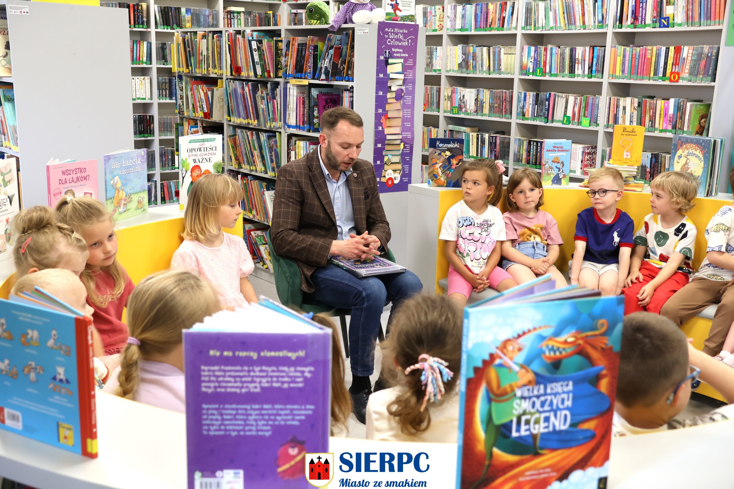 Zdjęcie grupowe przedszkolaków w Miejskiej Bibliotece im. Z. Nałkowskiej w Sierpcu z Zastępcą Burmistrza Miasta Sierpca Piotrem Nowakowskim.