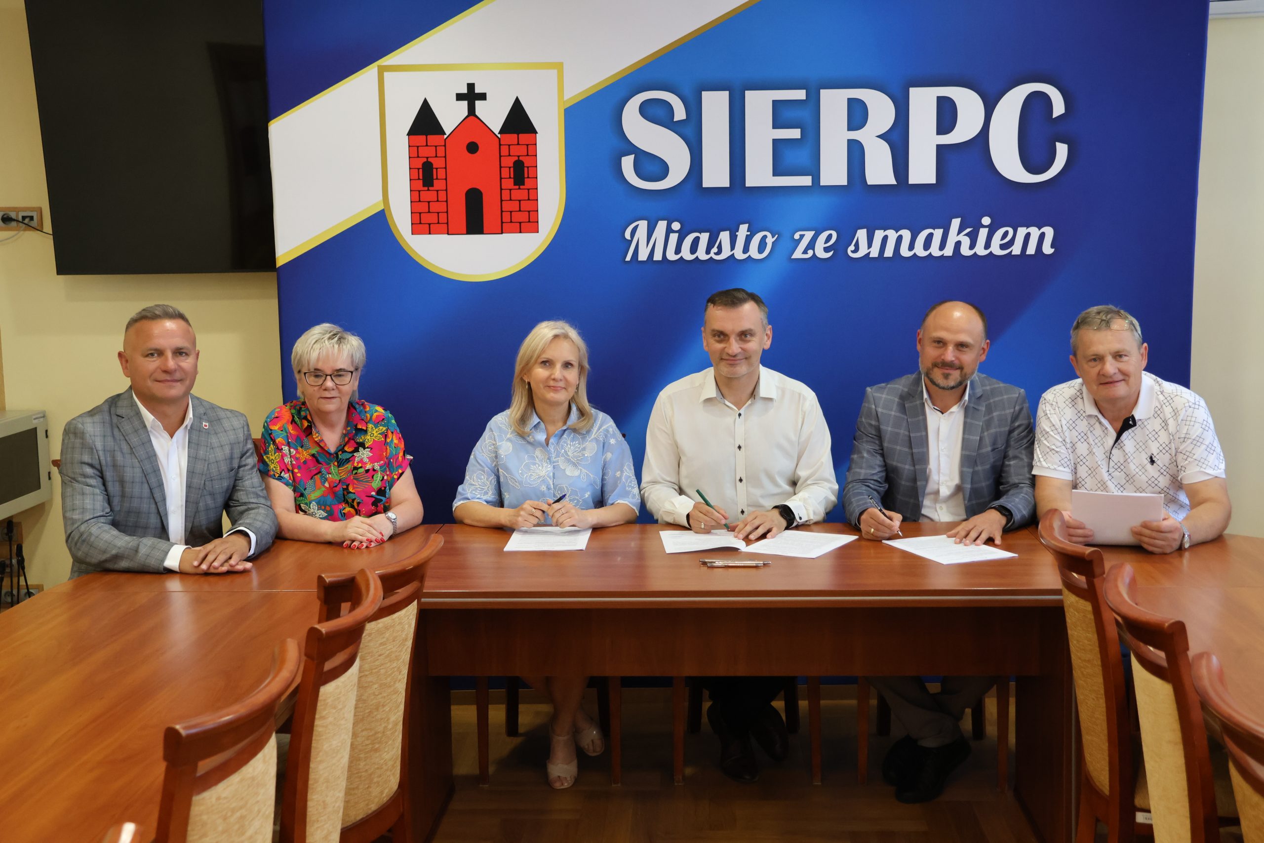 Zdjęcie z podpisania umowy na budowę boiska wielofunkcyjnego przy Szkole Podstawowej nr 3 w Sierpcu. Na zdjęciu widoczny Burmistrz Miasta Sierpca, Wykonawca zadania, Skarbnik Miejski, dyrektor Szkoły Podstawowej nr  3 w Sierpcu oraz Radni Rady Miejskiej Sierpca: Zbigniew Długokęcki i Waldemar Frydrychowicz.