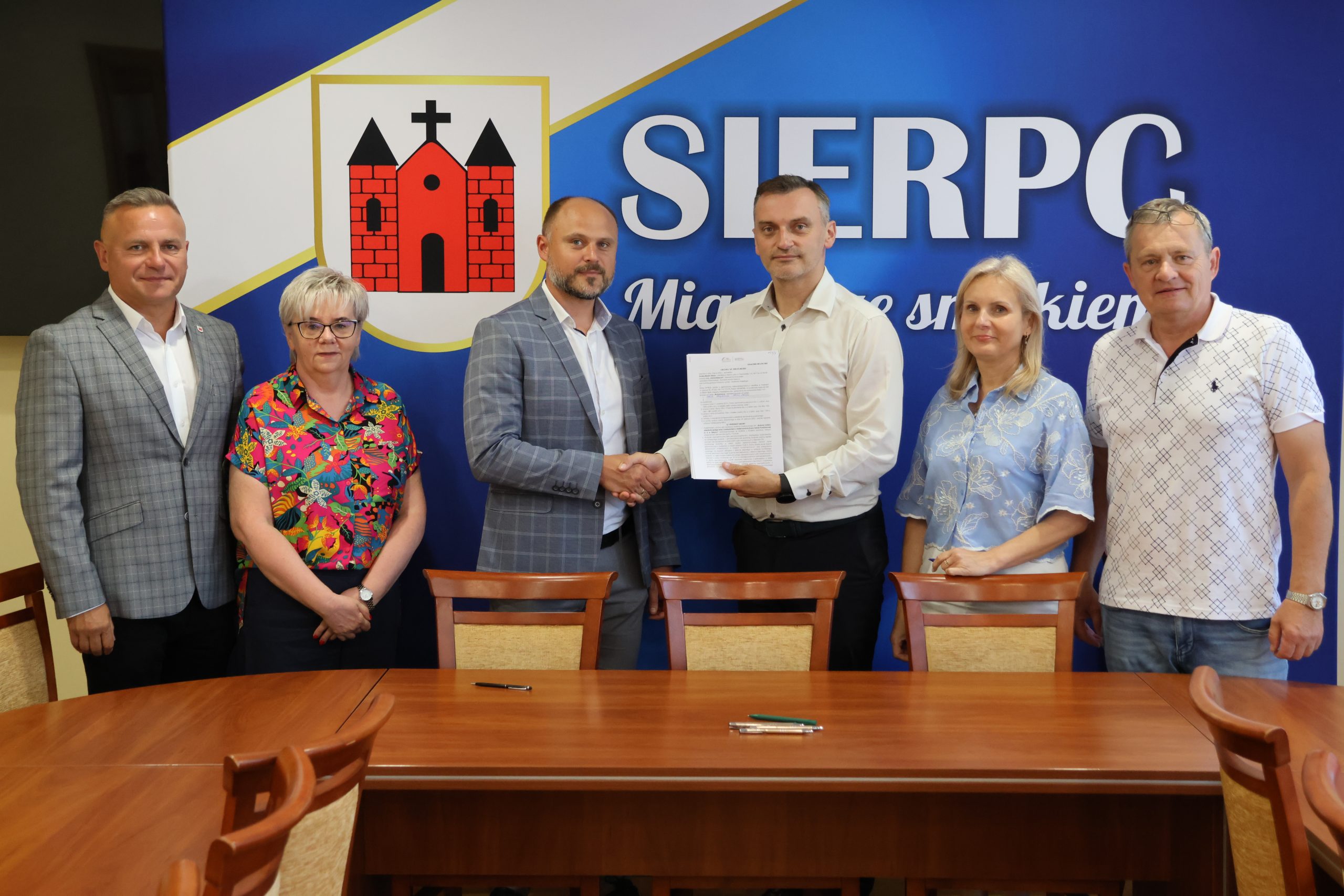 Zdjęcie z podpisania umowy na budowę boiska wielofunkcyjnego przy Szkole Podstawowej nr 3 w Sierpcu. Na zdjęciu widoczny Burmistrz Miasta Sierpca, Wykonawca zadania, Skarbnik Miejski, dyrektor Szkoły Podstawowej nr  3 w Sierpcu oraz Radni Rady Miejskiej Sierpca: Zbigniew Długokęcki i Waldemar Frydrychowicz.